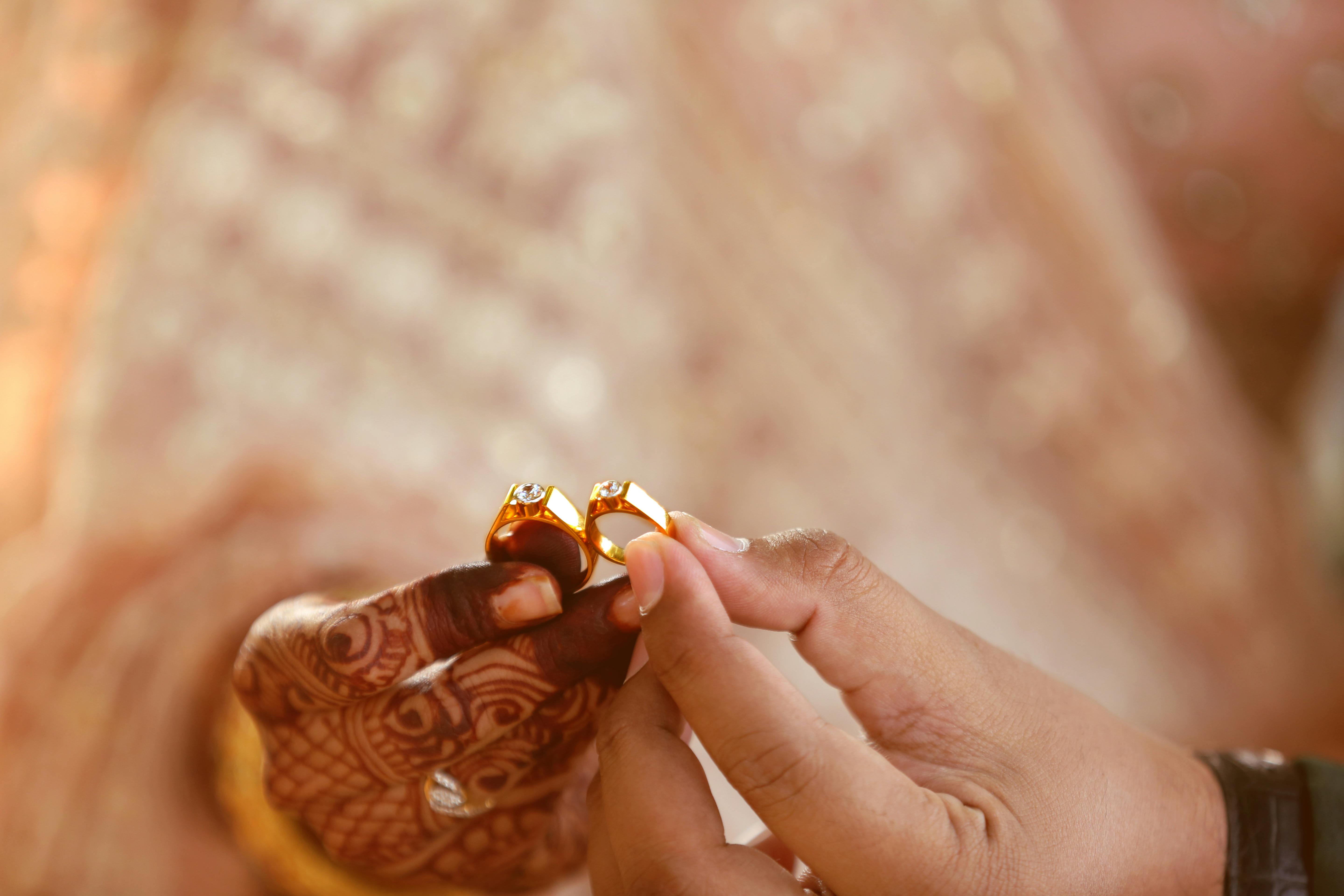 hands holding gold rings