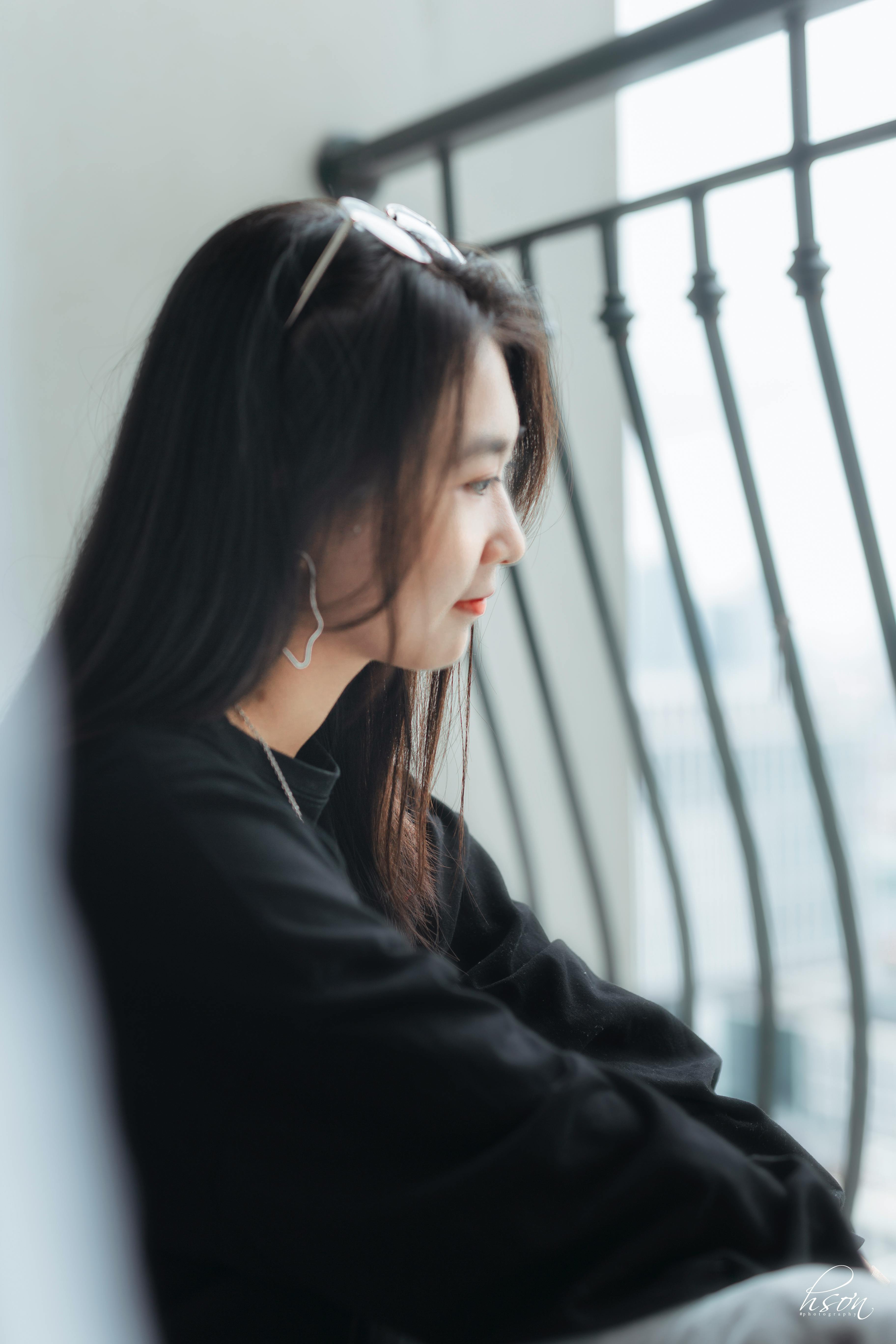 young ethnic woman daydreaming on balcony