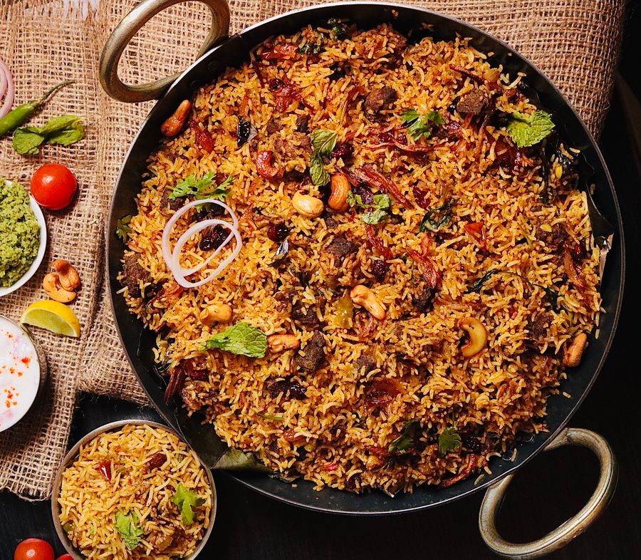 Biryani cooking in a large pan