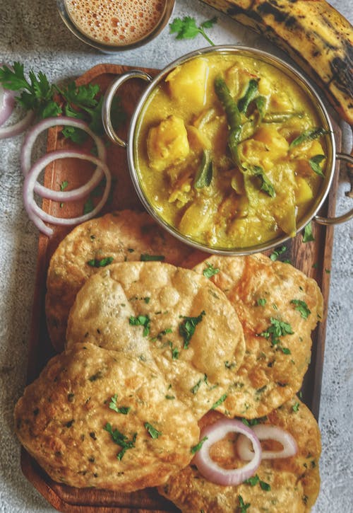 Dish with Yellow Sauce and Fried Round Dish on Brown Wooden Tray