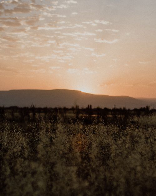Free Peaceful mountain landscape at sunset with a scenic field view and warm colors. Stock Photo