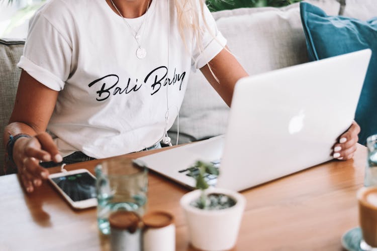 Person In White Crew Neck T-shirt Sitting In Front Of Silver Laptop 