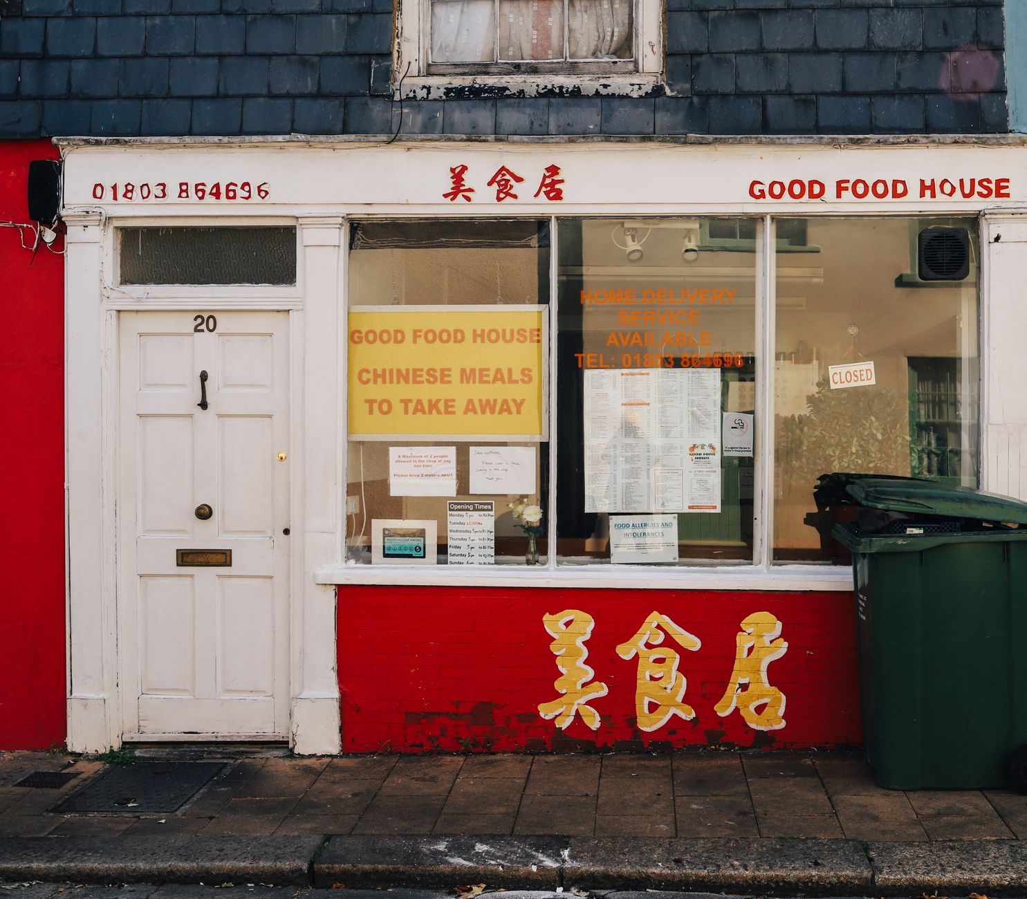 A colorful exterior of a Chinese takeaway named 'Good Food House' with vibrant signage and classic elements.