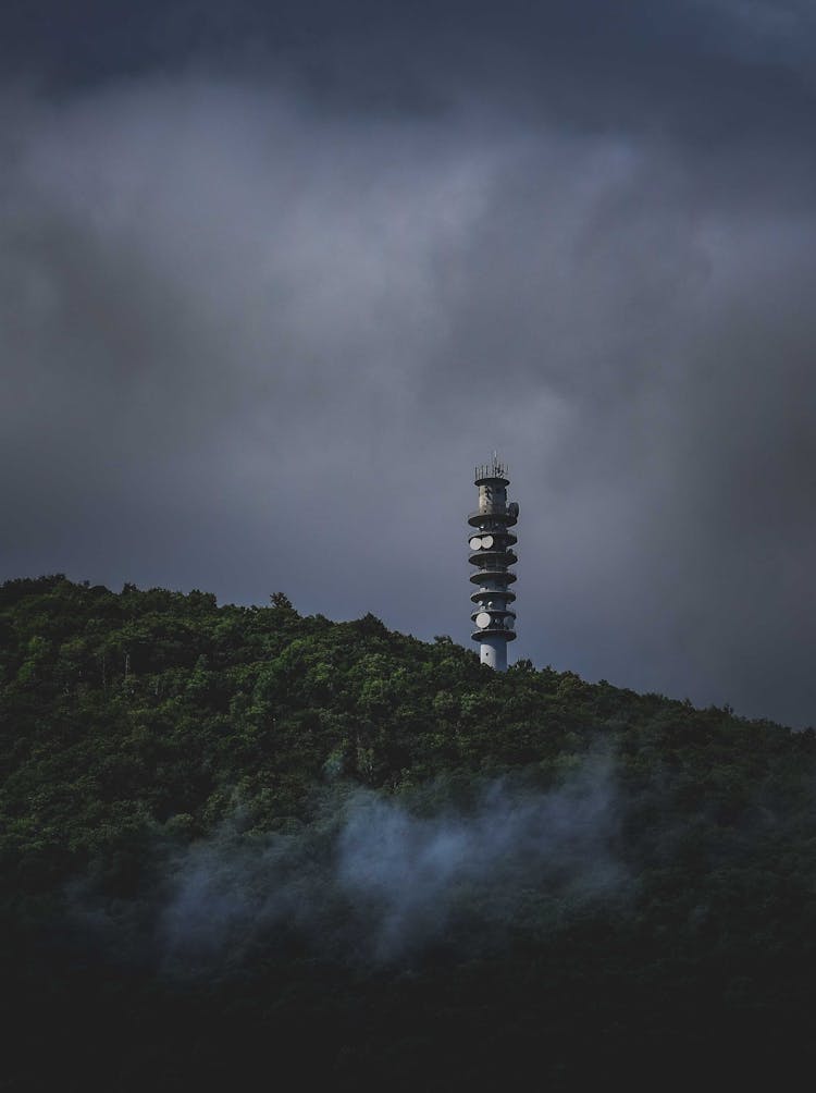 Tower With Satellite Dishes Against Dramatic Sky