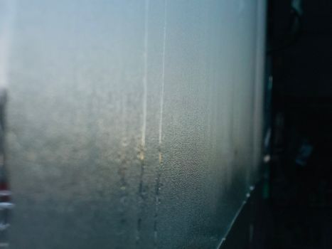 雨天拍摄的潮湿玻璃表面特写，带有抽象图案