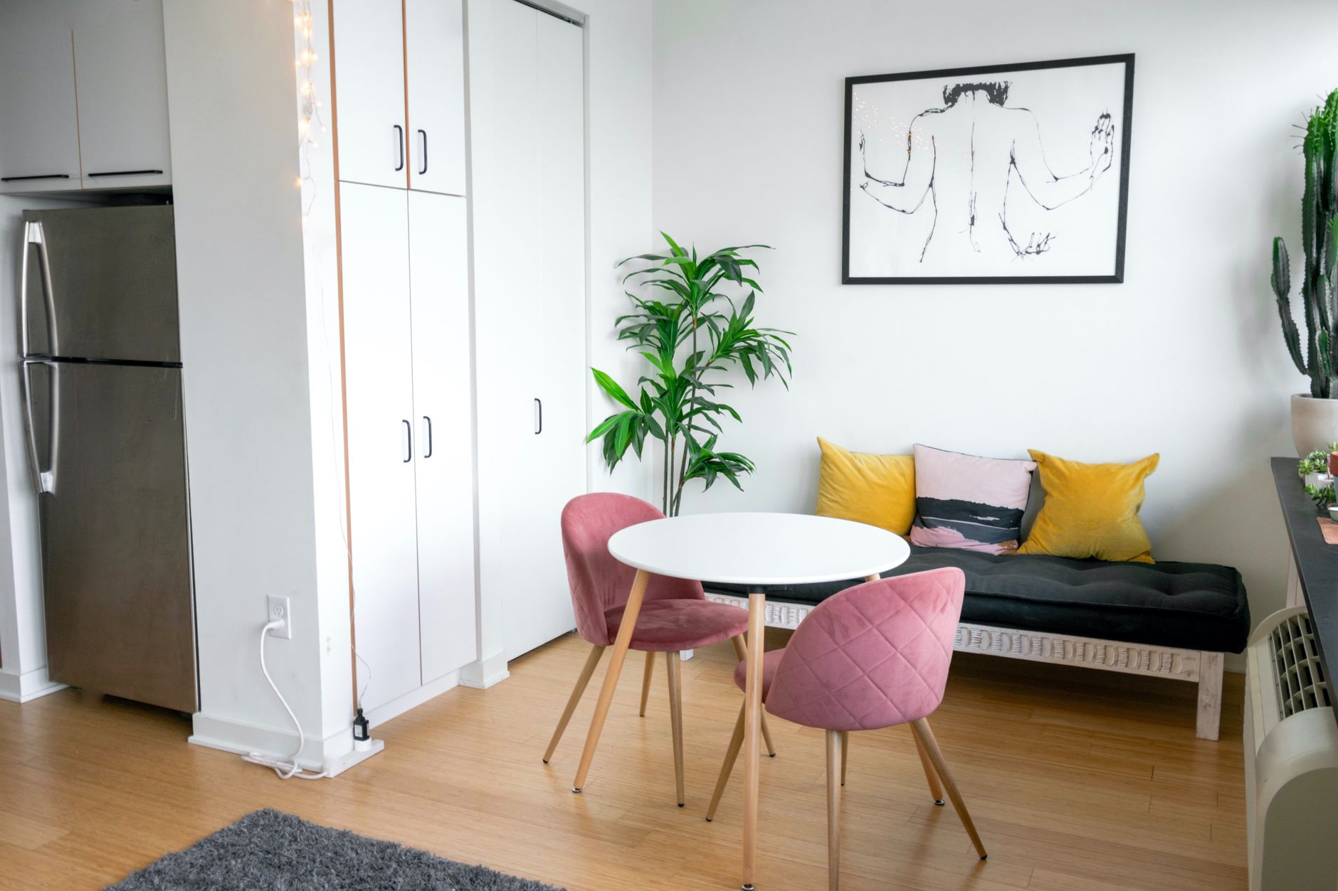 modern apartment upgrade on a budget Contemporary room interior with table and armchairs near bench with decorative cushions on parquet at home
