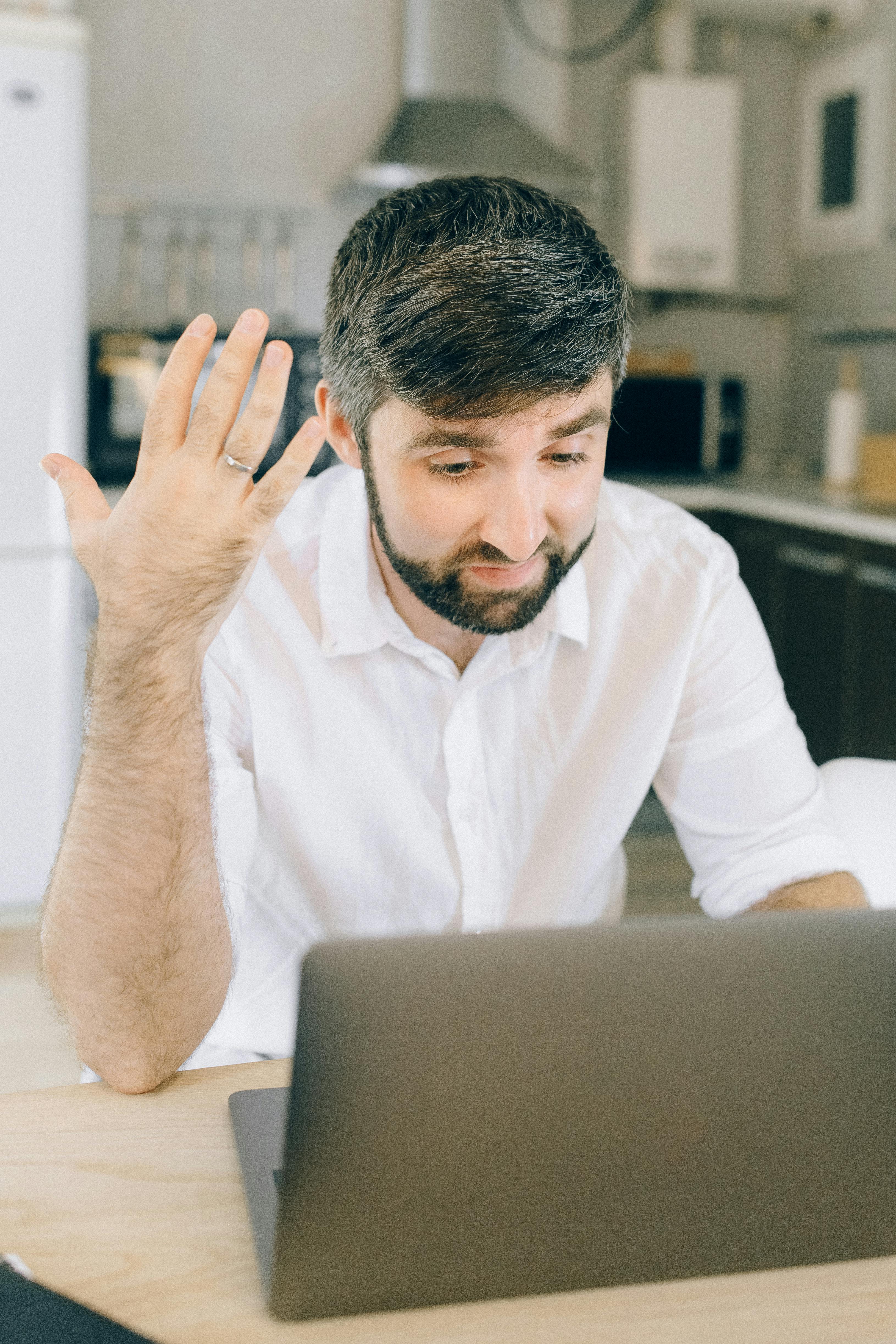 a man using a laptop while taking on a video call