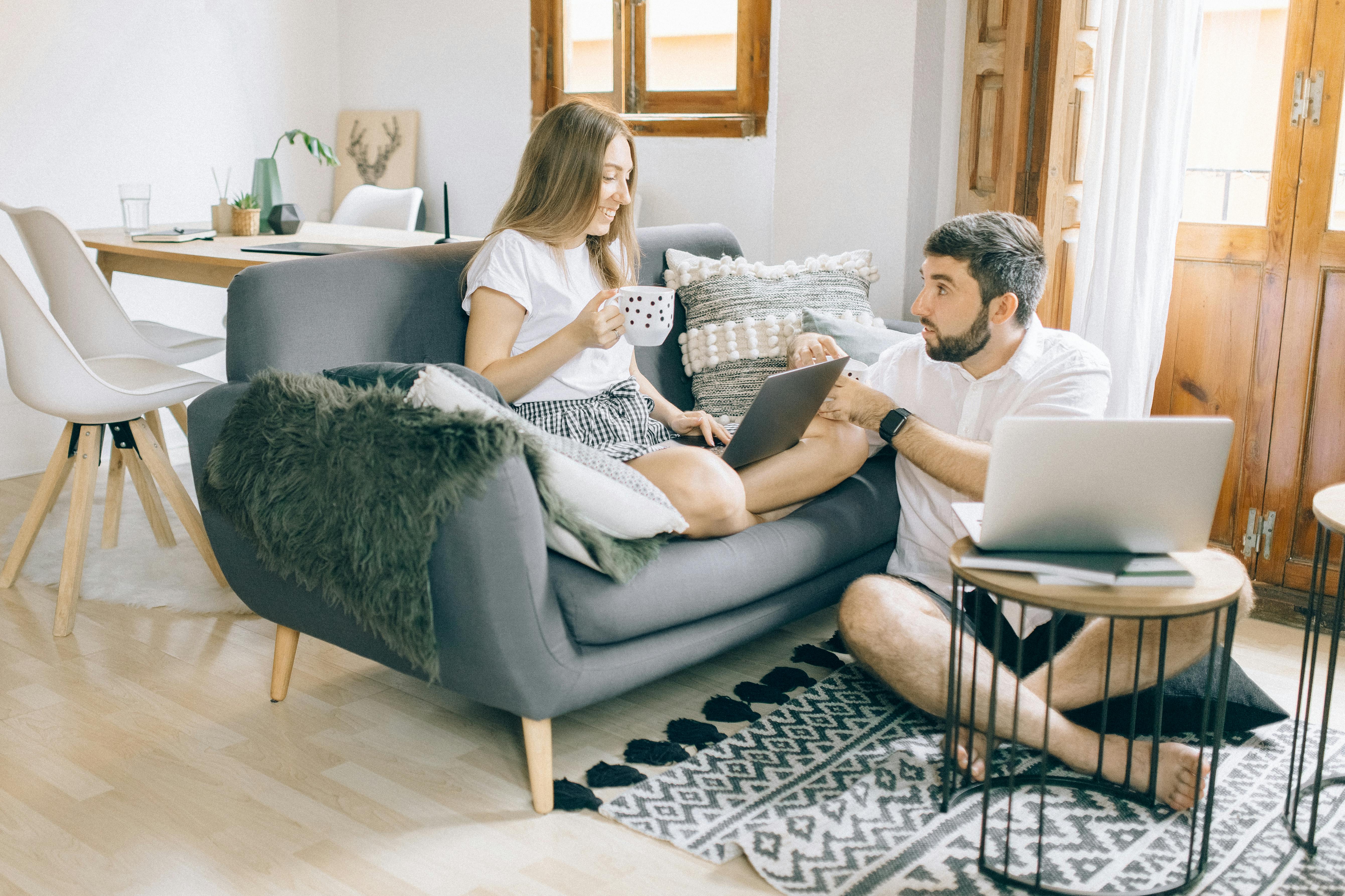 man and woman talking while working at the living room