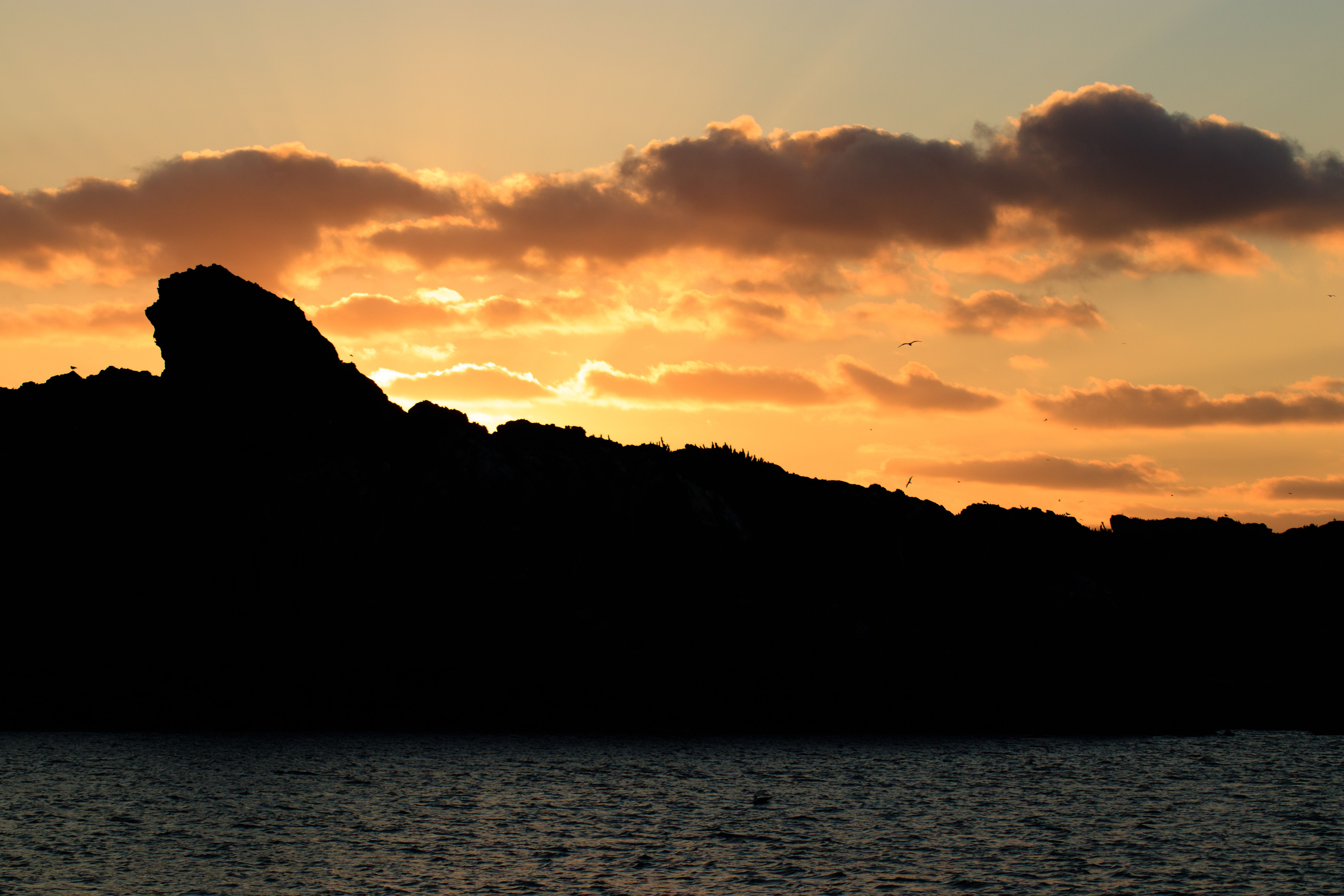 Silhouette of Mountain Near the Sea during Sunset · Free Stock Photo