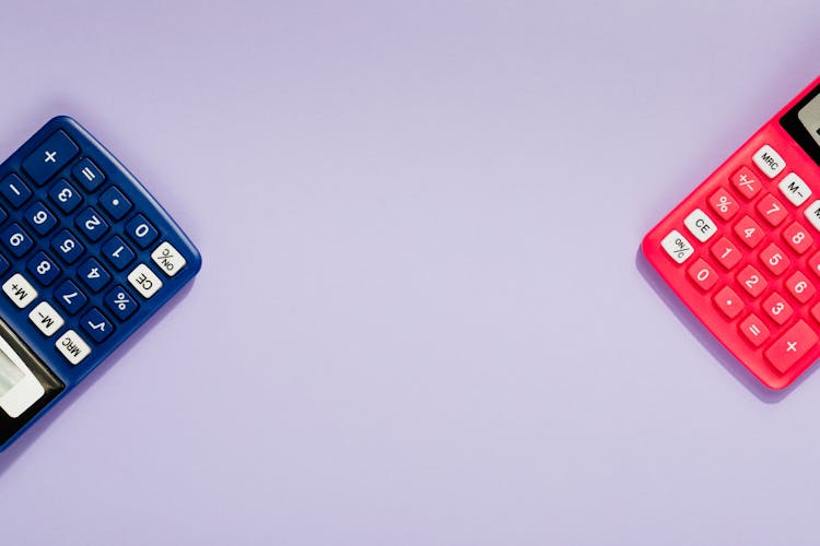 Close-Up Shot Of Calculators On A Purple Surface