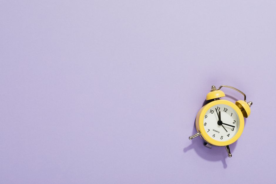 Photo by https://kaboompics.com/ on Pexels A vibrant yellow alarm clock on a purple surface with ample copy space, perfect for design projects. - Photo by https://kaboompics.com/ on Pexels