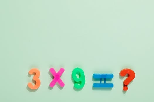Colorful magnetic numbers and symbols on a pastel backdrop pose a math question.