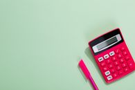 Pink and White Calculator Beside Purple Pen