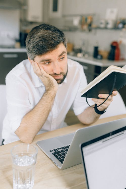 Free Man in White Dress Shirt Holding a Notebook Stock Photo