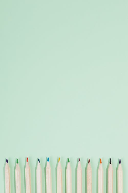 Free Wooden Colored Pencils on Light Green Surface Stock Photo