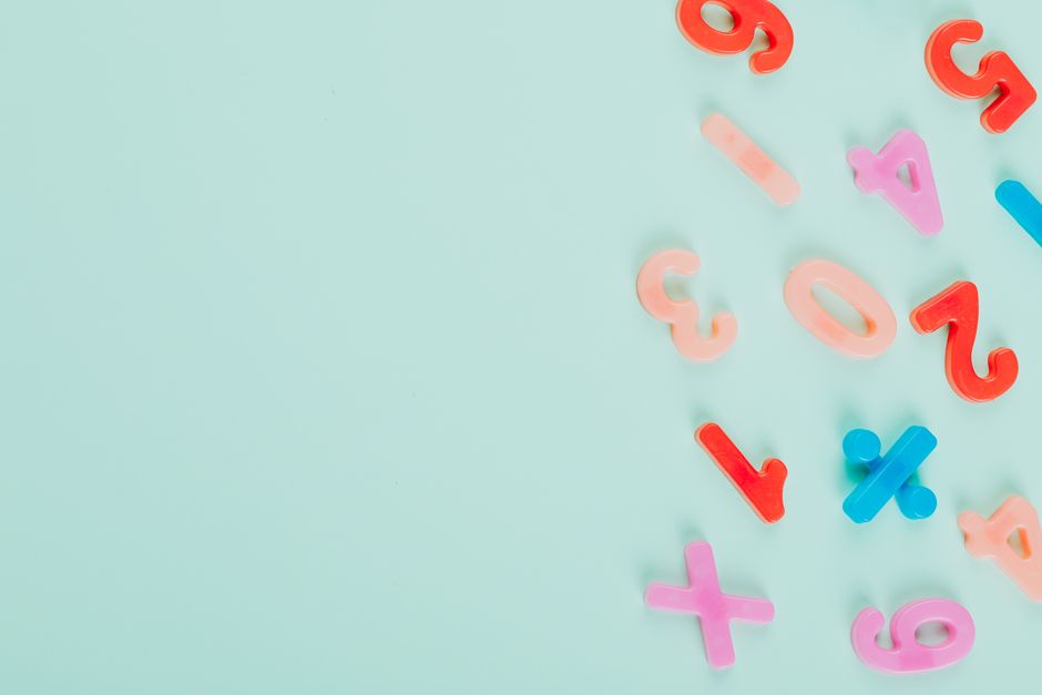Vibrant plastic numbers arranged on a light teal backdrop with ample copy space.