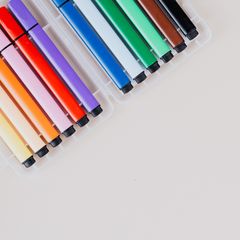A row of colourful felt pens in a clear tray