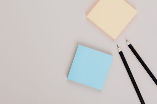 Free Top view of colorful sticky notes and sharp pencils on a neutral surface, minimalism style. Stock Photo