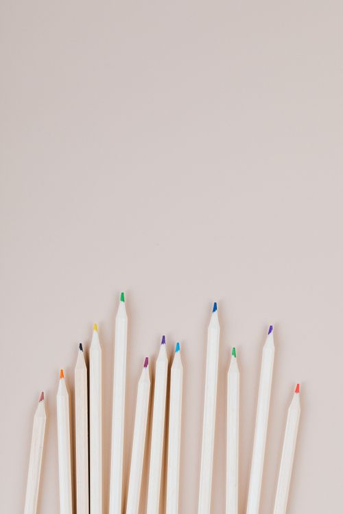 Free Vertical shot of colorful wooden pencils on a beige background with copyspace. Stock Photo