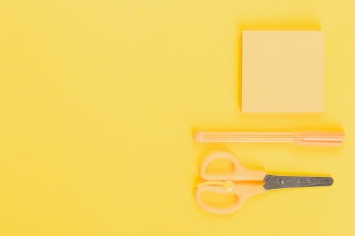 Free Yellow Sticky Note and Pen Beside a Scissor Stock Photo