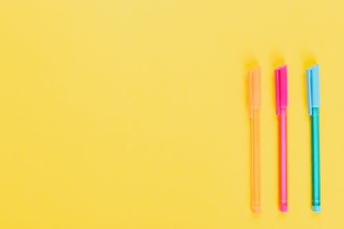 Gratis stockfoto met flatlay, geel oppervlak, gekleurde pennen