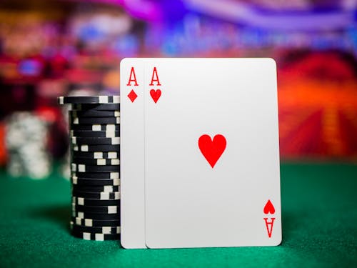 Playing Cards Beside and Casino Chips on Green Table