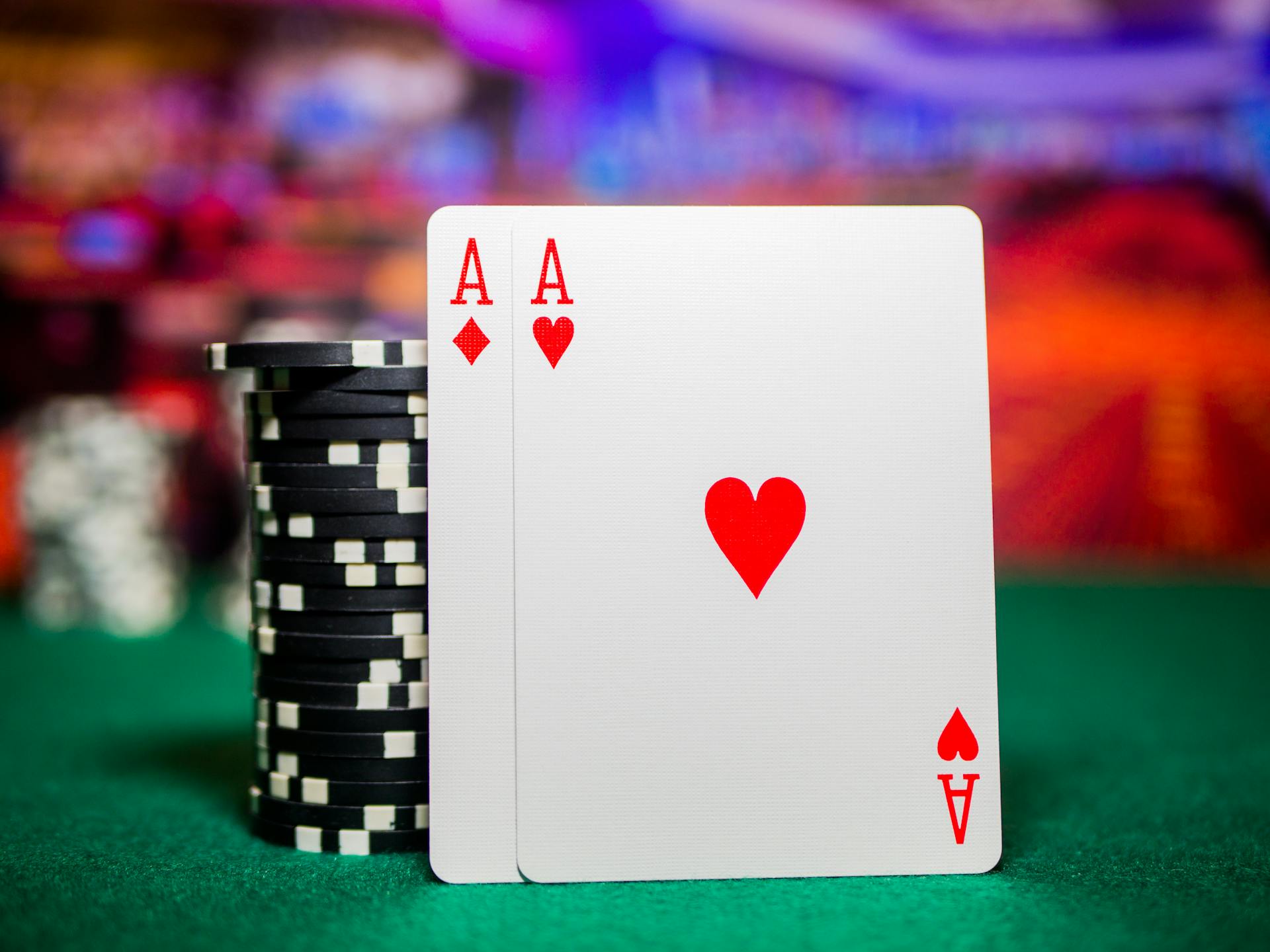 Close-up of poker chips and aces on a green felt casino table, perfect for gambling themes.