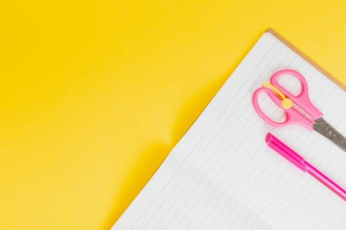 Free Pink Pen and Scissors on the Notebook  Stock Photo