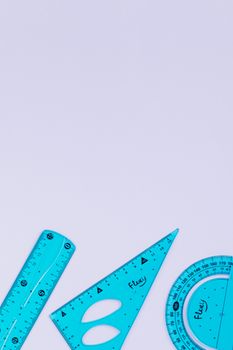 Assorted blue measuring tools with ample copy space on a purple background.