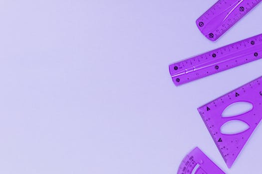紫色尺子和量针置于极简主义背景中，留有充足的复制空间