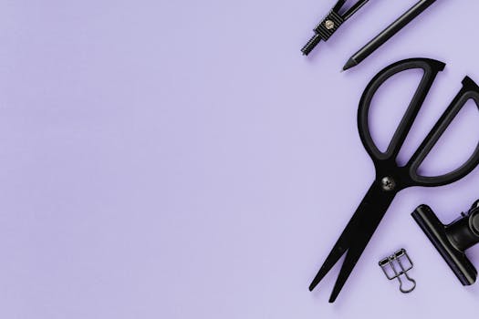 黑色学习用品平放在紫色背景上，带有复印空间