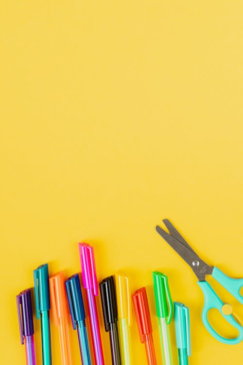 Gratis stockfoto met bovenaanzicht, gekleurde pennen, gele achtergrond