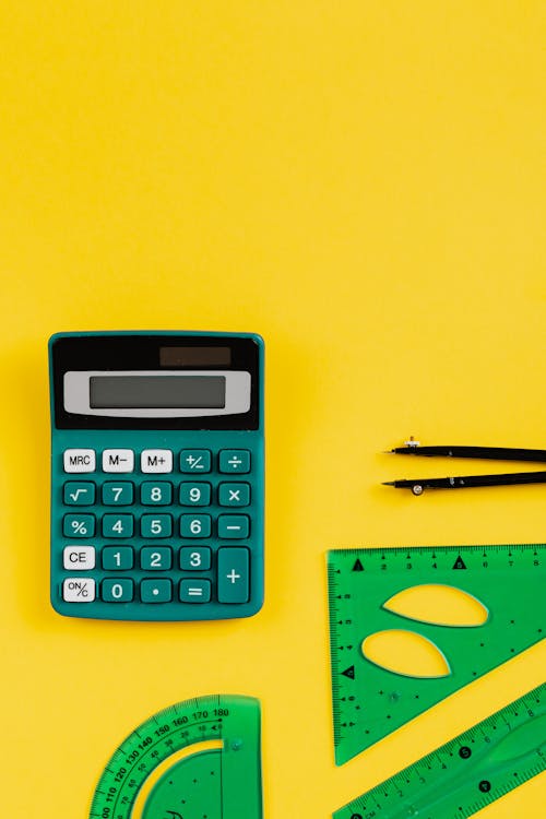 Free Green Calculator On Yellow Background Stock Photo