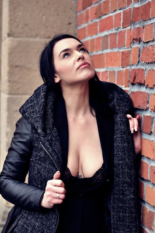 Woman in Black Leather Jacket Leaning on a Brickwall