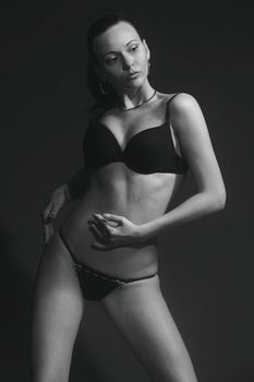Black and white portrait of a woman posing in lingerie, showcasing elegance and style.