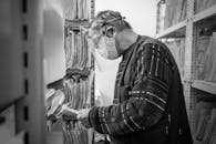 A Man Wearing Facemask and Face Shield Searching for Records
