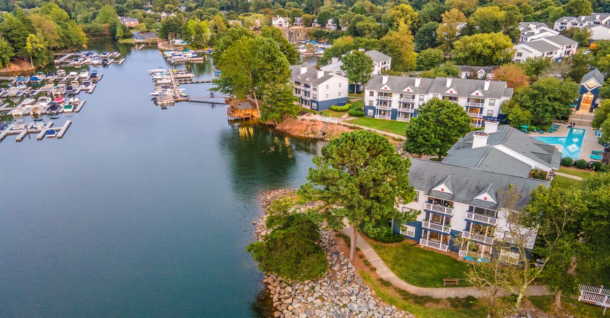 A scenic aerial view of a waterfront community in Cornelius, North Carolina featuring a marina and residential buildings.