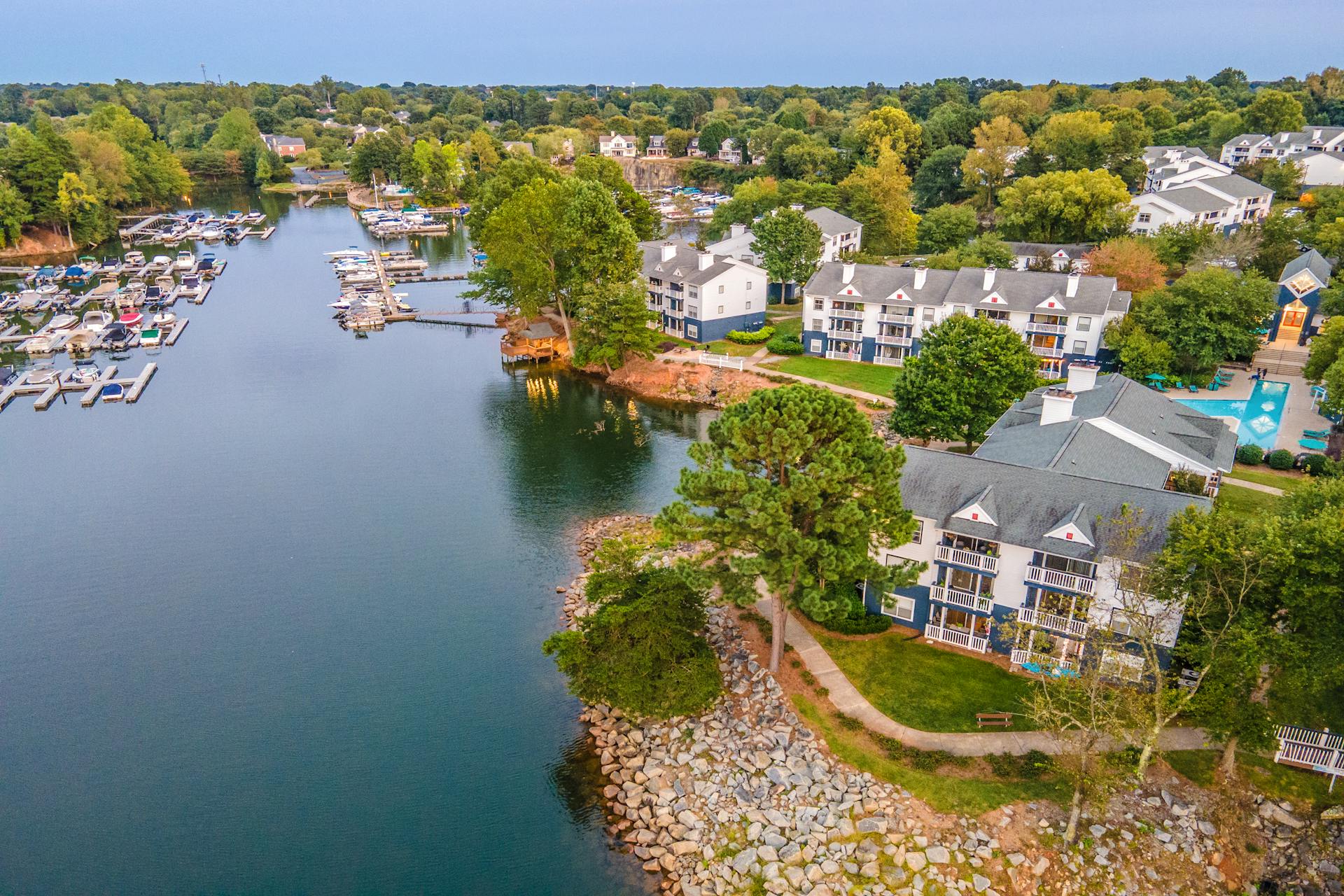 A scenic aerial view of a waterfront community in Cornelius, North Carolina featuring a marina and residential buildings.