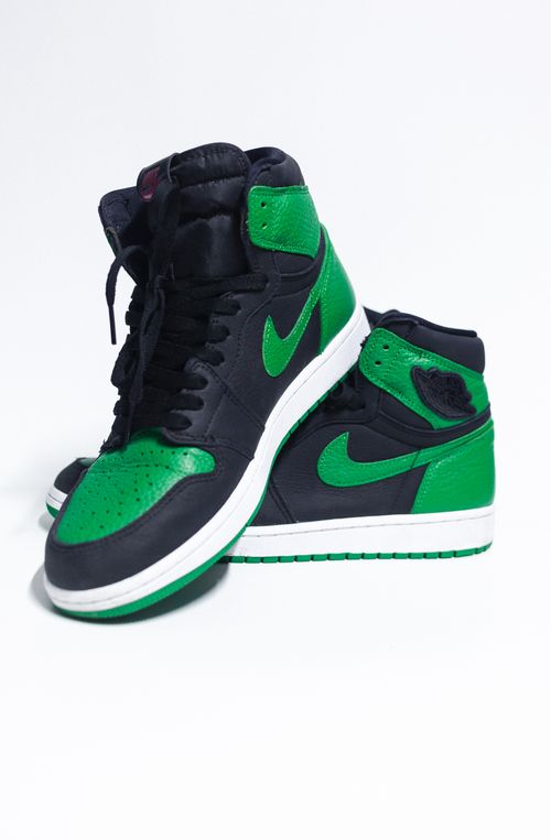 Free Close-up of green and black high-top sneakers with shoelaces and brand logo on a white background. Stock Photo