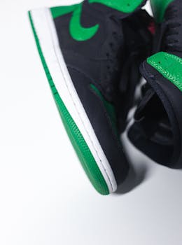 Detailed close-up of black and green sneakers displaying design and texture.