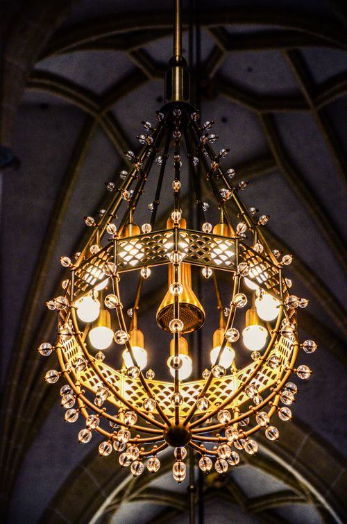 Free Intricate gold chandelier lighting up the ornate interior of a Munich cathedral. Stock Photo