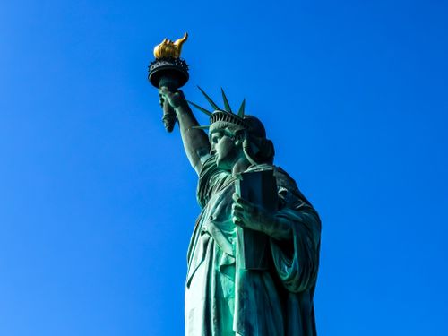 Free Close-up of the Statue of Liberty with a vibrant blue sky backdrop in New York City. Stock Photo