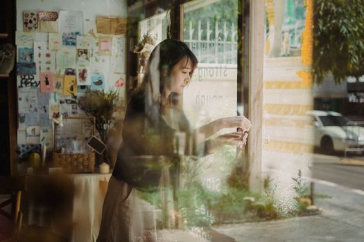 透过咖啡馆的窗户，沉思的女人的倒影营造出一种梦幻而舒适的氛围