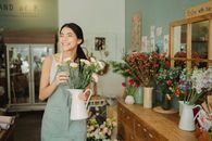 一家迷人的花店里，一位快乐的花艺师正在布置新鲜的花朵