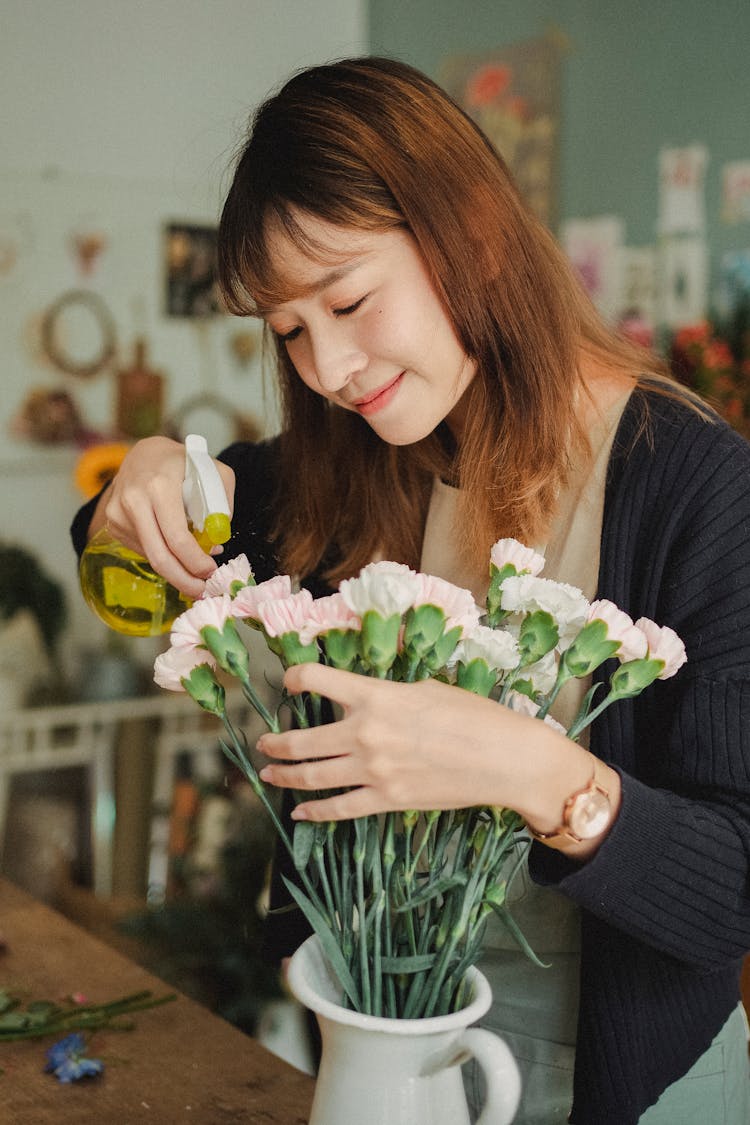 Woman Watering Flowers In Vase