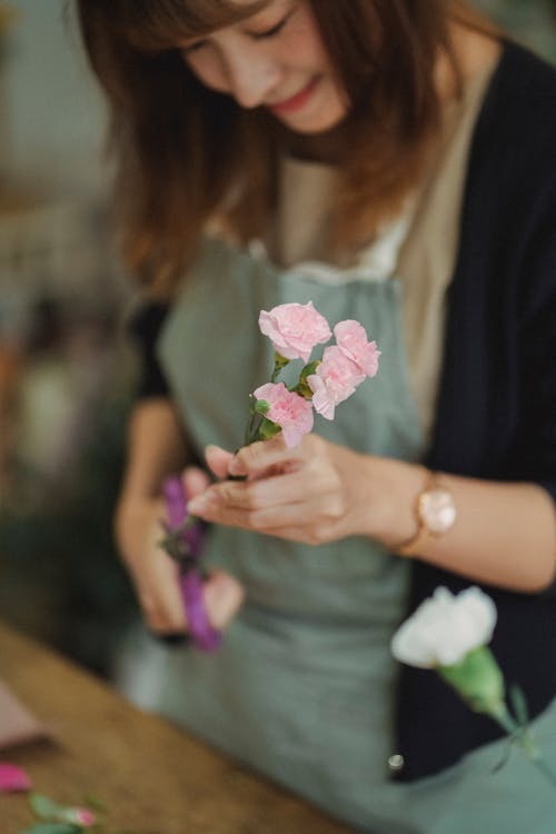 Флорист делает букет из свежих цветов в магазине