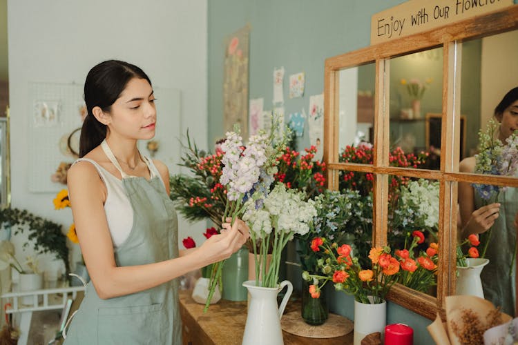 Florist  Standing Near Counter With Flowers