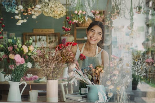 Floristería Feliz De Pie Junto A La Ventana De La Tienda De Floristería