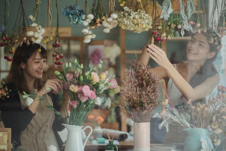 Cheerful Diverse Florists Decorating Floral Shop Window