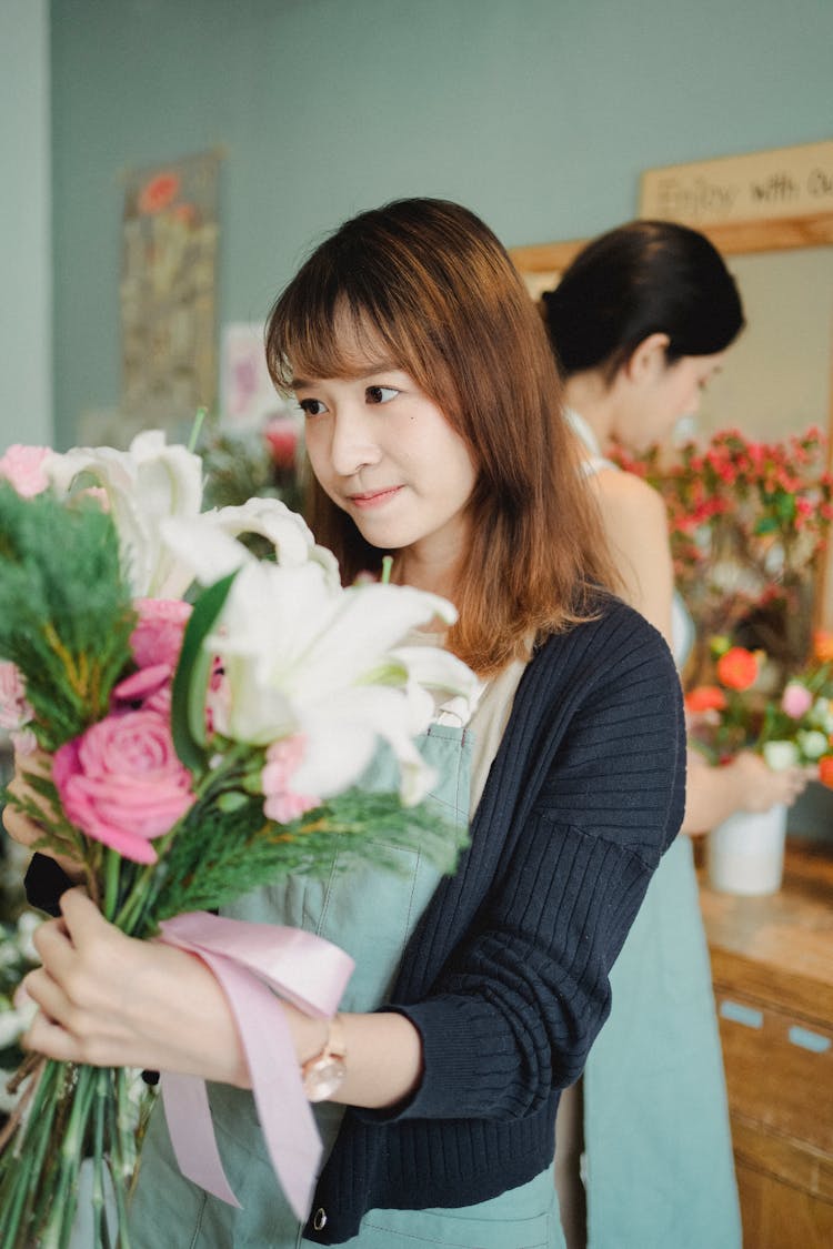 Charming Asian Florist Standing With Bouquet In Floral Shop